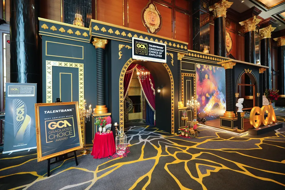 A themed entrance arch with the GCA letters, red curtains and gold detail at a gala