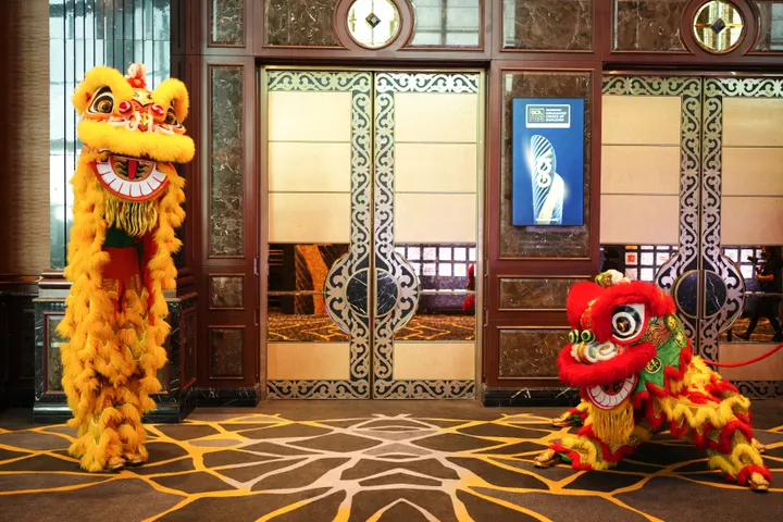 Two lion dance costumes at the entrance of a ballroom before a gala begins
