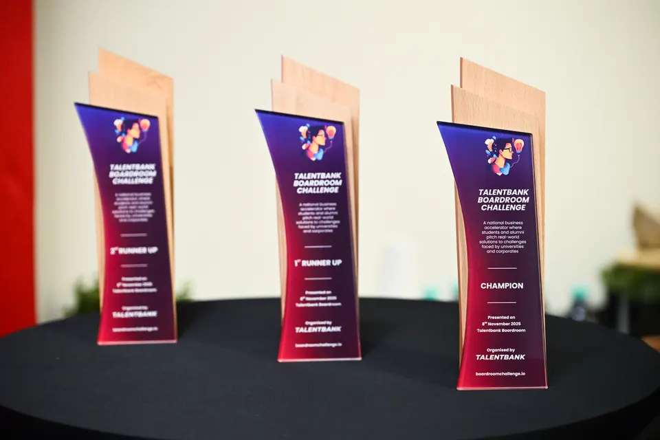 Three tall award trophies on a black-draped table