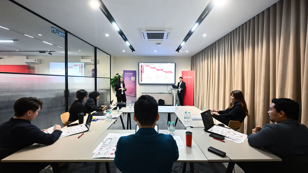 A team presenting on screen to a judging panel seated around a U-shaped table in a meeting room