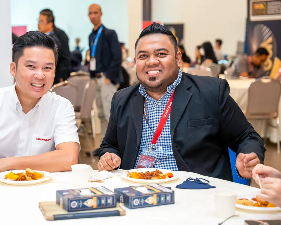 Two guests smiling at a lunch table during a Talentbank graduate recruitment dialogue