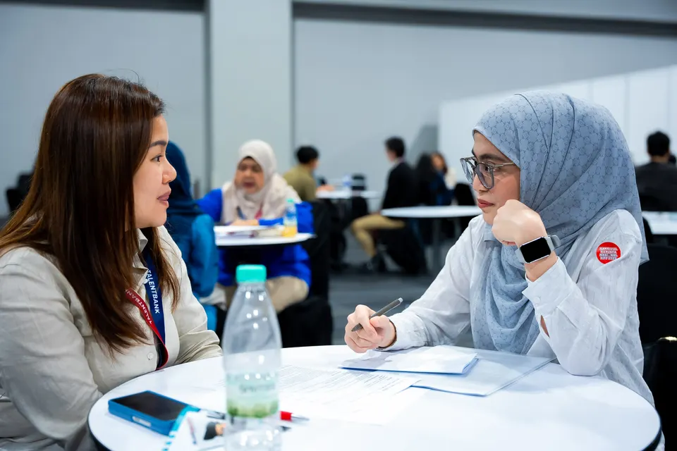 A mentor and a candidate reviewing a document together at a round table