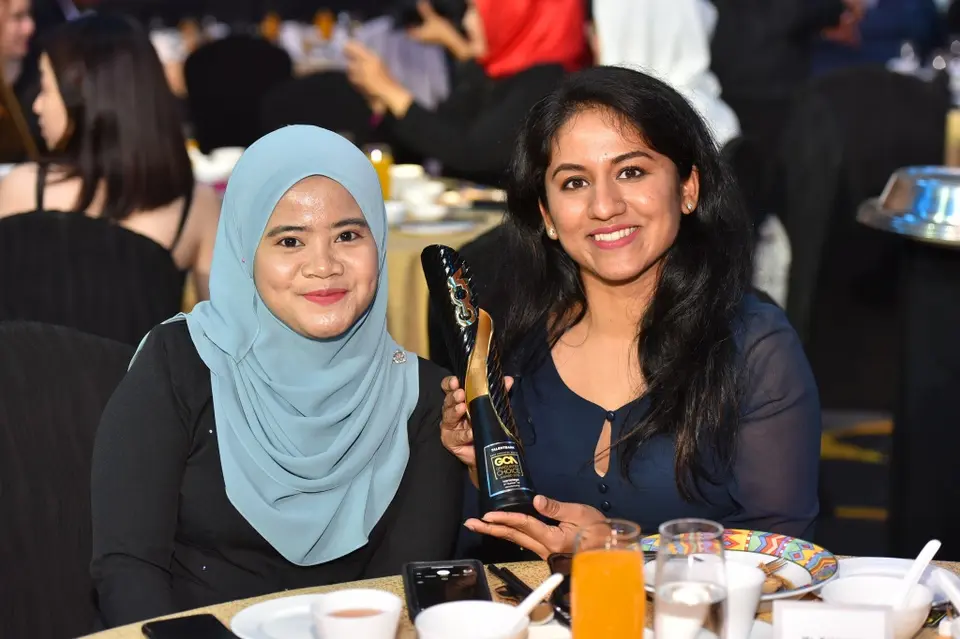 Two guests with a trophy at their table in 2019