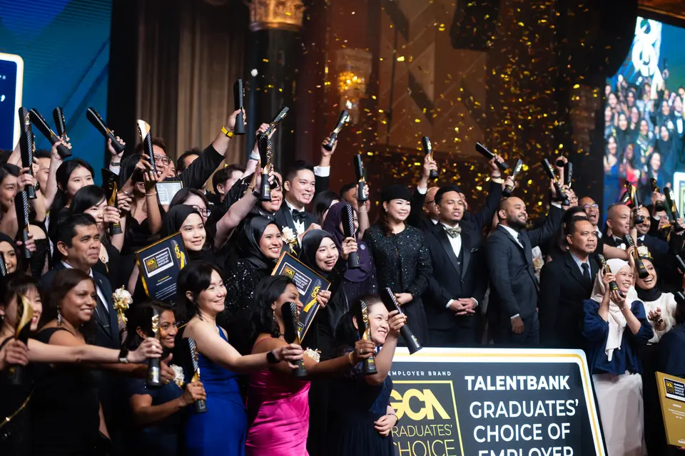 Winners holding their trophies under falling confetti
