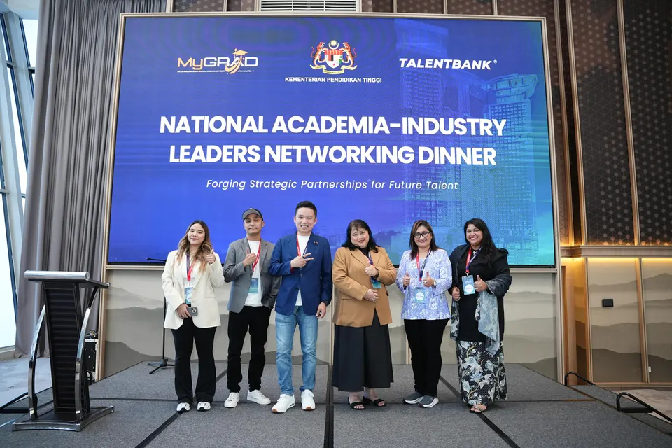 Six guests posing on stage in front of a screen reading National Academia-Industry Leaders Networking Dinner