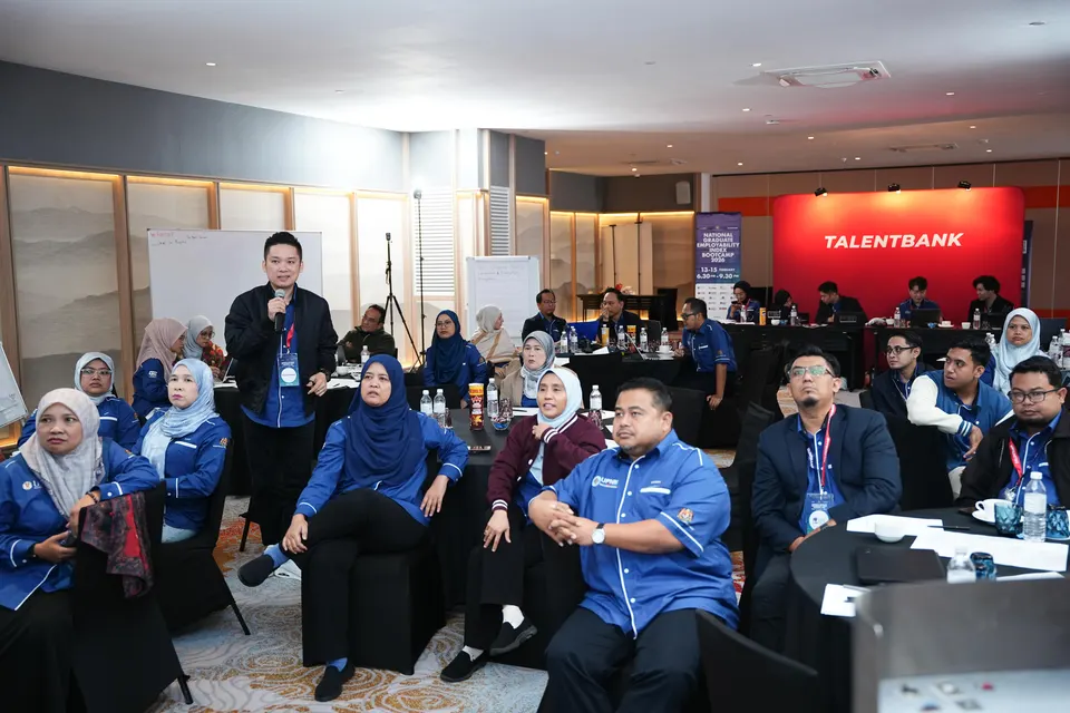 Bootcamp participants seated at round tables in a hotel meeting room as a Talentbank speaker addresses them