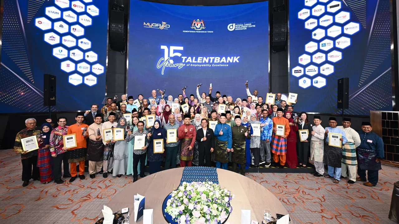 Representatives of Malaysian universities on stage holding Employers' Choice of University certificates and trophies, in front of a screen of university logos