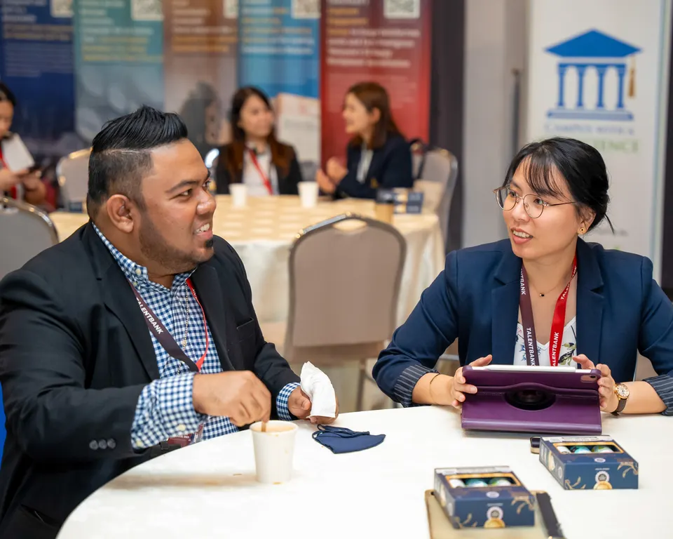 Two delegates in conversation at a round table during a Talentbank Graduate Recruitment Dialogue