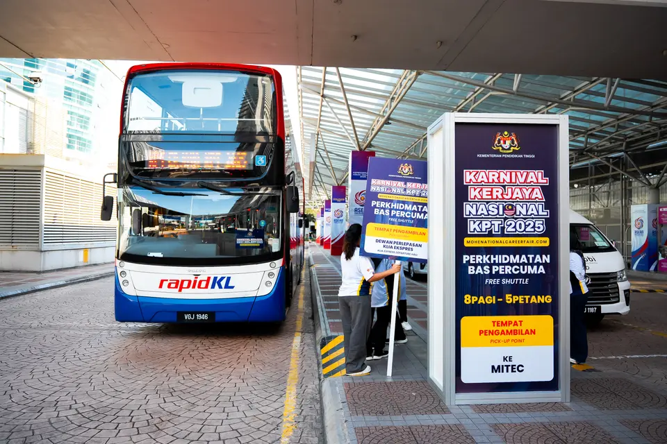 A double-decker shuttle at its stop, beside the free shuttle sign