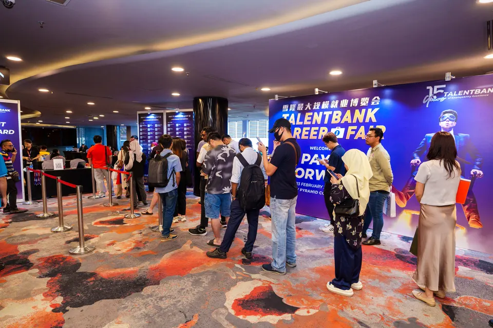 Visitors queueing in front of the Pay It Forward backdrop to meet mentors at the Talentbank Career Fair 2025