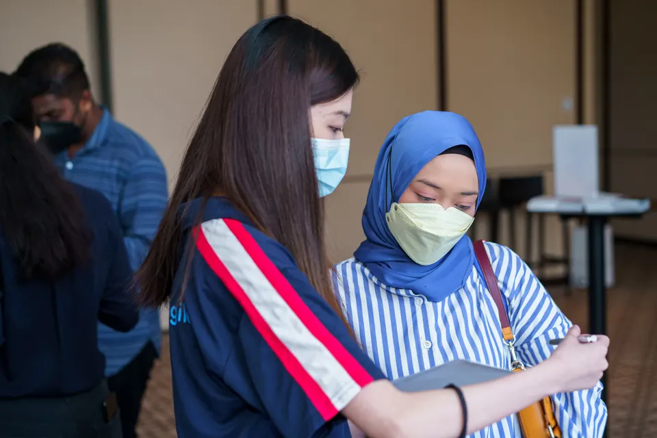 A member of the Talentbank crew guiding a candidate with a form