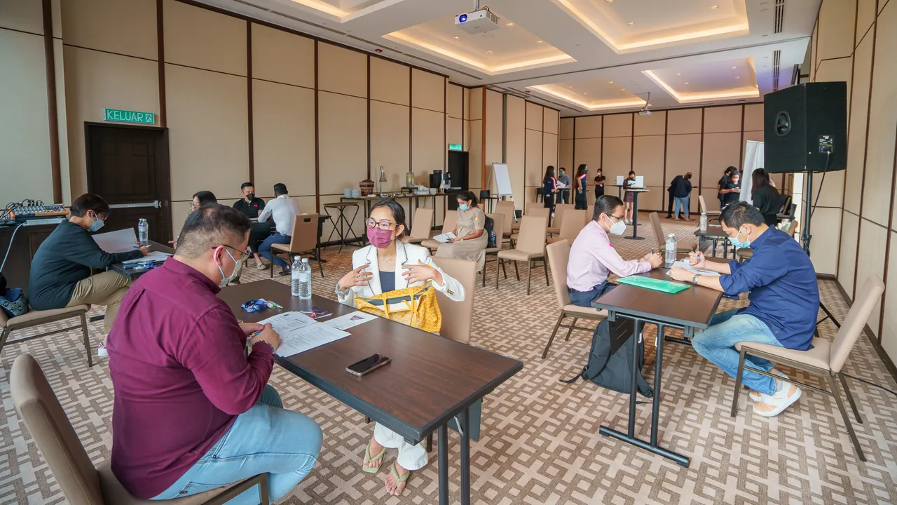 Candidates in one-to-one interviews with recruiters in a function room set up for a recruitment drive