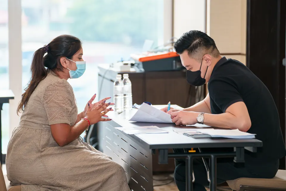 A candidate in conversation with an interviewer across a table