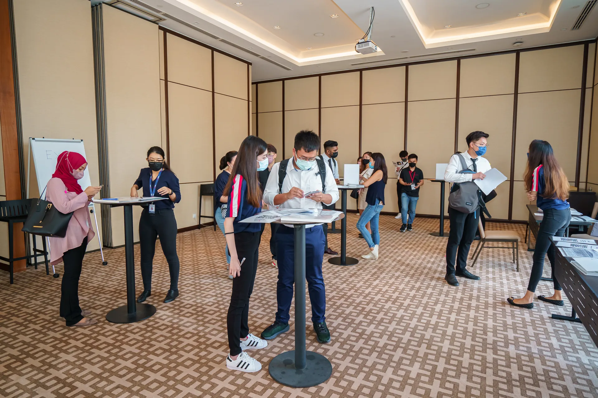 Candidates and the Talentbank crew at standing tables in a function room during a recruitment drive